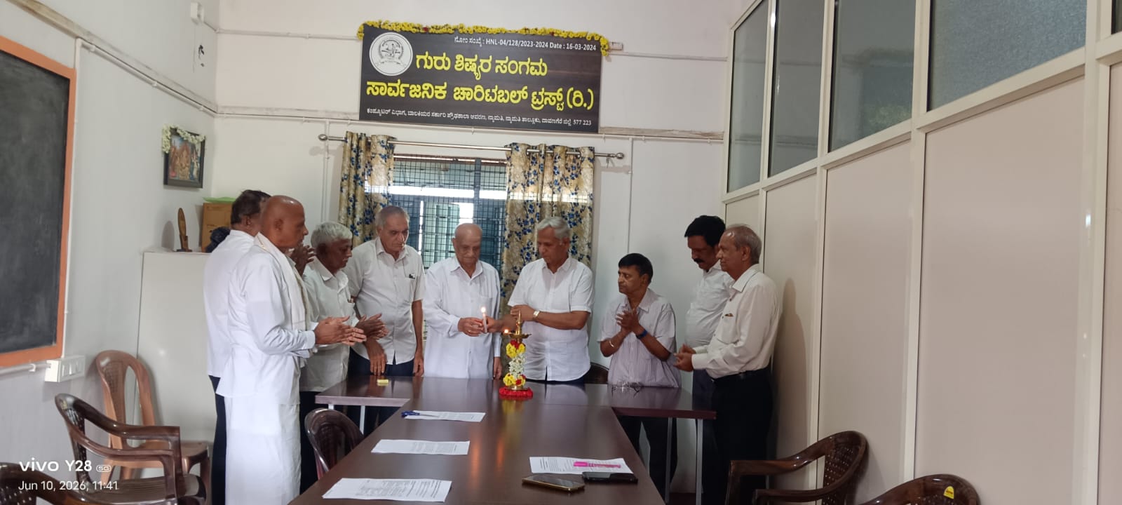 Trustees around the meeting table as the lamp is lit