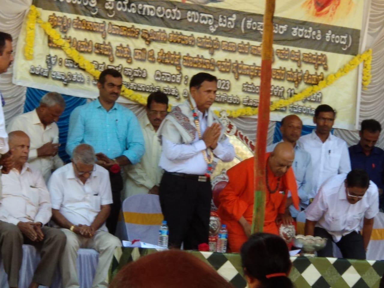 A guest on stage beneath the computer lab inauguration banner