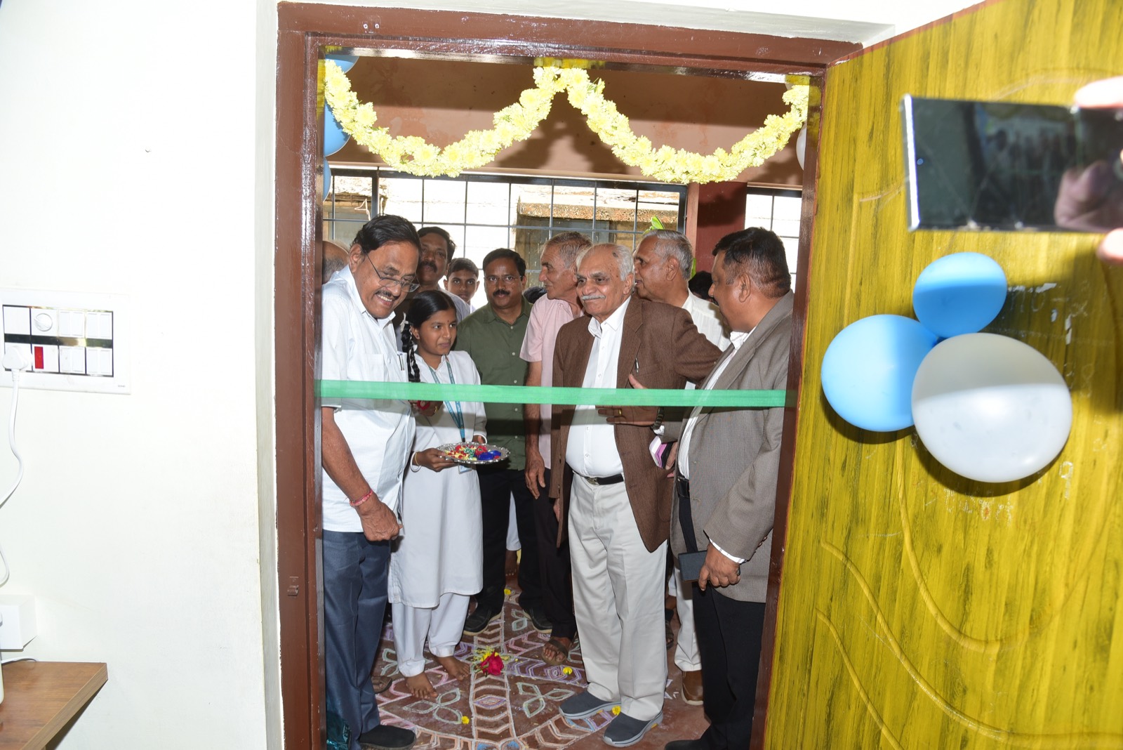 Trustees and guests cutting the ribbon at the door of the new computer lab
