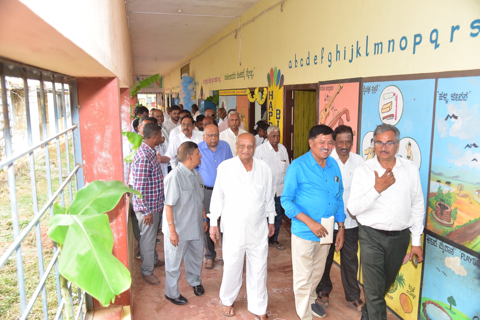 Trustees and guests walking along the school's brightly painted corridor