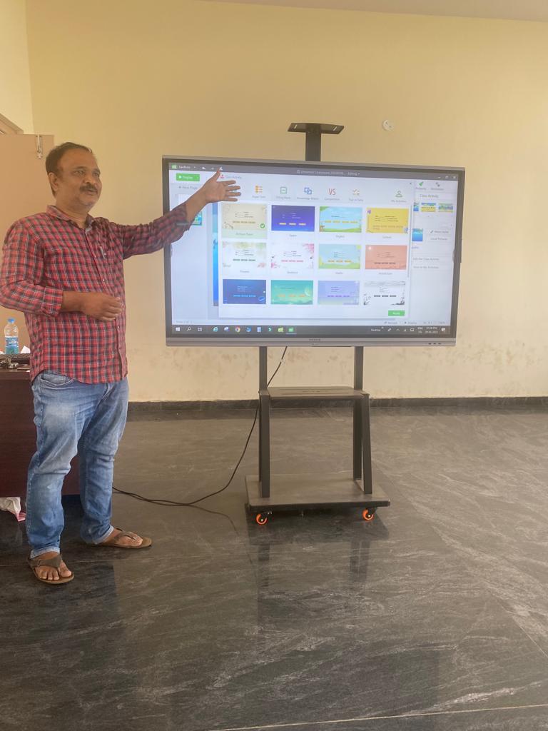 A man demonstrating a smart board on a mobile stand